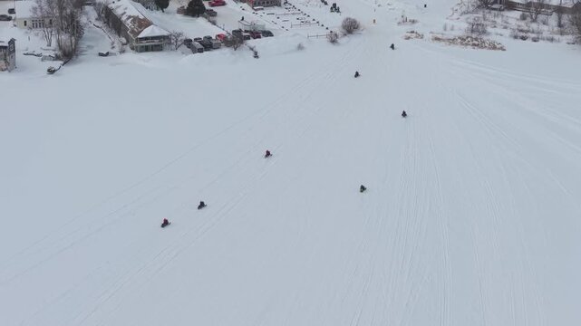 Drone Footage of Snowmobiles Riding Across Frozen Snow-Covered Lake in Northern Vermont 