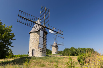 Two traditional windmills standing on rural hills in Montagne © Richard Semik