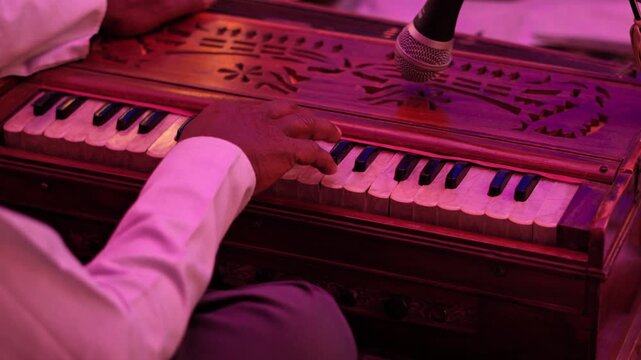 Indian Classical Harmonium Performance &ndash; Artistic Close-Up. Live Harmonium Music with Warm Pink and Purple Lights. Cultural Music Performance Featuring Harmonium Instrument.