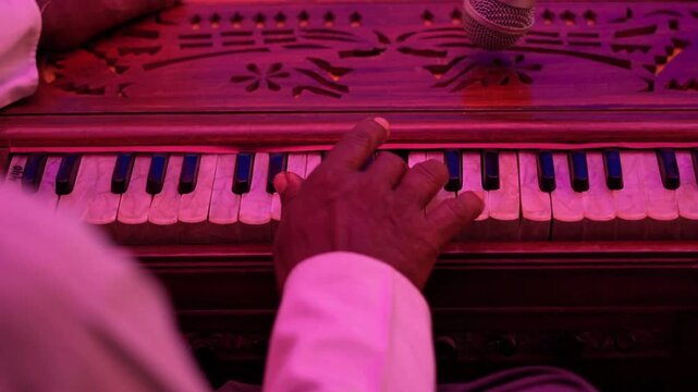 Playing Harmonium Under Stage Lights &ndash; Traditional Music Performance. Traditional Indian Harmonium Music with Warm Pink Lighting.