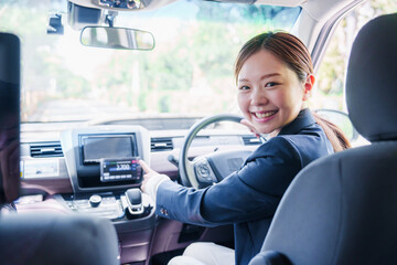 笑顔で料金の案内をするタクシードライバーの女性