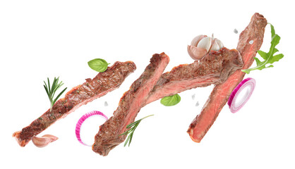 Fototapeta premium Roasted beef pieces, herbs, onion and garlic flying in air on white background