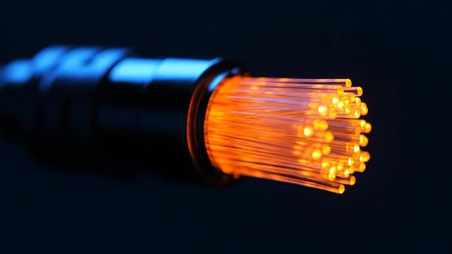Closeup of illuminated fiber optic cable strands emitting orange and blue light against a dark background.