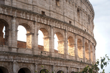 An intimate, textured close-up of the Colosseum's iconic walls in Rome. Deep grooves, pockmarks, and layered stone blocks of the ancient amphitheater, telling a story of millennia under Italian sun.