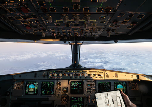 Pilot flying commercial airplane over clouds using efb