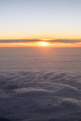 Obraz premium Golden sun creating light over clouds and mountains