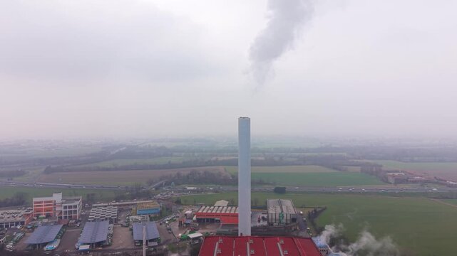 Industrial smokestack emitting polluting smoke into overcast sky