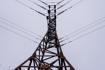 Deliveri Energy Tower Supports Electrical Lines in Cloudy Sky During Daylight Hours in Urban Area