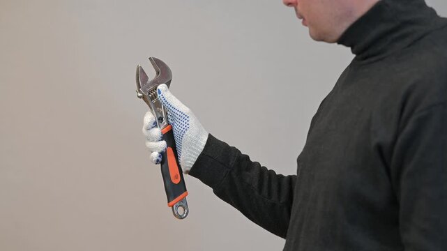 Handyman holding adjustable wrench tool. Professional plumbing and mechanical maintenance service concept.
