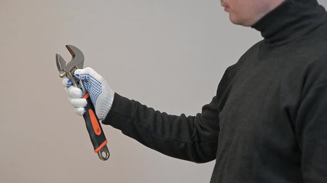 Handyman holding adjustable wrench tool. Professional plumbing and mechanical maintenance service concept.