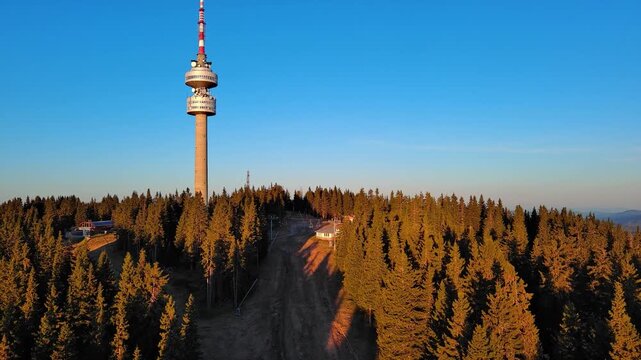 Tower Snezhana on peak of Snezhana covered with spruce forests in Rhodope mountains