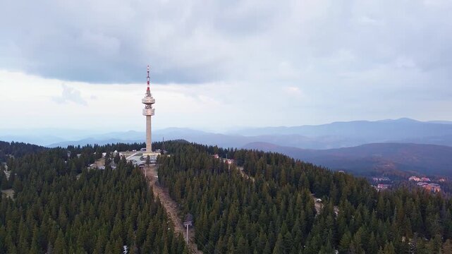 Tower Snezhana on peak of Snezhana covered with spruce forests in Rhodope mountains