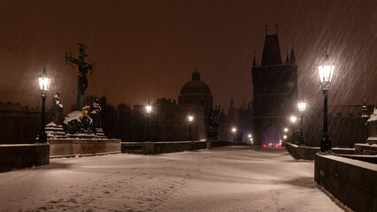 Obraz premium Winter morning with lit gas lamps on the snowy Charles Bridge