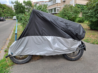 Black and gray cover on motorcycle parked in the yard of a buildings © Harmony Video Pro