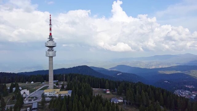 Tower Snezhana on peak of Snezhana covered with spruce forests in Rhodope mountains