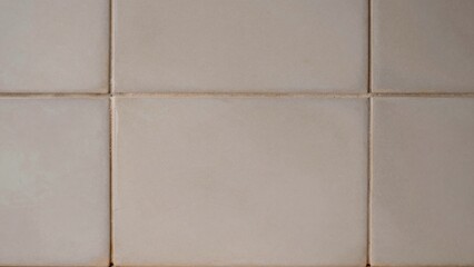 Fototapeta premium Close-up beige ceramic tile wall composed square tiles arranged grid pattern predominantly color have smooth