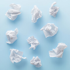 Crumpled white tissue paper pattern on blue background, abstract minimal flat lay texture