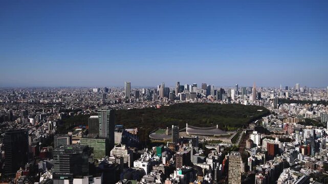 Tokyo, Japan, beautiful super wide aerial view of rooftops and skyscrapers, with skyline and city wards scenery, from the observation deck in a sunny day with a blue sky, Tokyo Metropolitan urban area