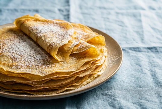 Stack of Spanish Frisuelos crepes with powdered sugar