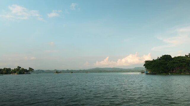 Relaxing boat journey across Kaptai Lake capturing calm water reflections green hills and scenic natural beauty of Rangamati Bangladesh.