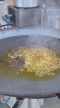 preparazione del soffritto con olio e aglio in una grande padella