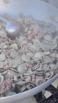 orecchiette pugliesi preparate in un pentolone durante una festa