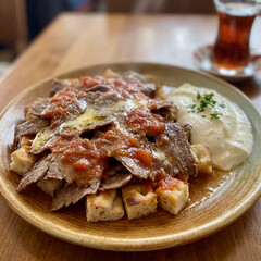  Iskender Kebab served with yogurt and a glass of Turkish tea.