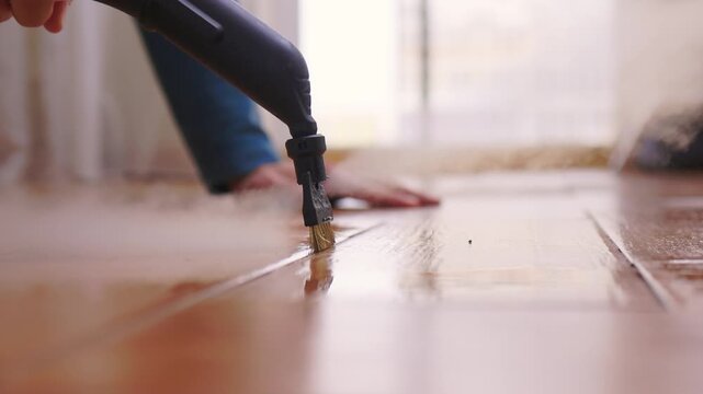 Vapor spray on tile grout. Closeup of steam removing stubborn grime from ceramics. Satisfying vapor cleaning technique revealing pristine and spotless ceramic grout lines