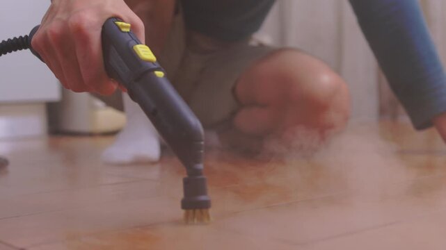 Vapor spray on tile grout. Closeup of steam removing stubborn grime from ceramics. Satisfying vapor cleaning technique revealing pristine and spotless ceramic grout lines