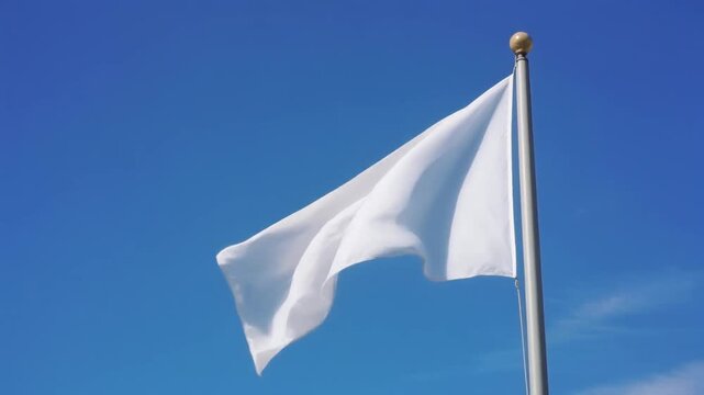 A plain white flag waves gently against a clear blue sky, symbolizing peace and surrender