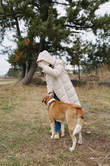 Obraz premium dog, person, coat, park, outdoor, hooded, beside a dog and its owner in a hooded coat within a park, trees in the background and a calm outdoor moment