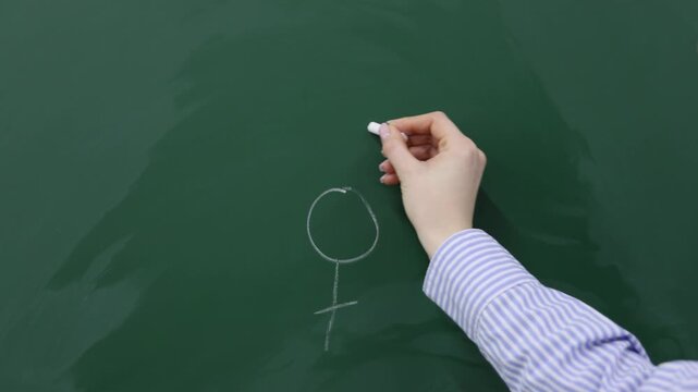 Sex Education. Woman drawing gender symbols on green chalkboard, closeup