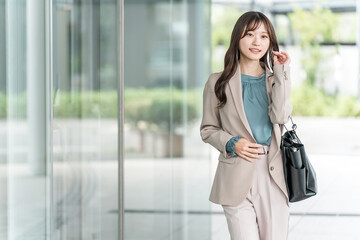 Fototapeta premium Young Asian businesswoman walking in an urban office district
