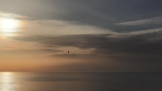 sunset over the sea with paraglider