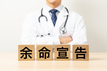 「余命宣告」と書かれたブロックと医師