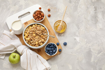 Fototapeta premium Bowls with tasty granola and ingredients on grey grunge background