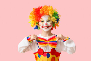 Fototapeta premium Little girl in clown costume on pink background. April Fools' Day celebration
