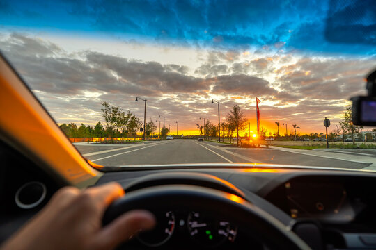 POV road trip through a Florida town, windshield framing the street and evening traffic creating a dynamic suburban scene.