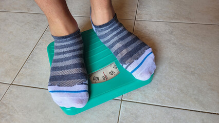 Person Weighing on Analog Scale with Striped Socks
