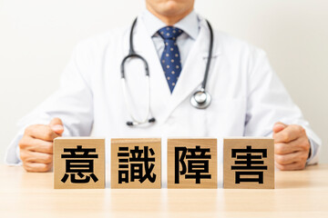 「意識障害」と書かれたブロックと医師
