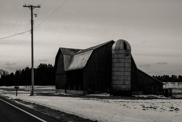 Obraz premium A historic barn by a country road during the winter in Northern Michigan