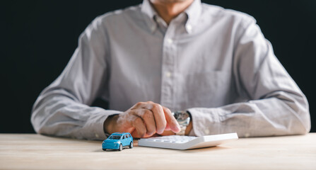 Insurance coverage calculation for auto finance, person uses calculator determining car loan money...