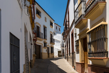 narrow street scene with buildings in Ronda, a town in the M&aacute;laga Province of Andalusia, Spain