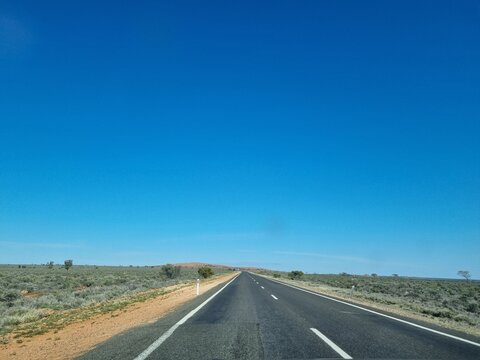 The Barrier Highway From Cobar to Broken Hill in the Australian Outback under a blue sky