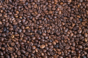 Extreme closeup freshly roasted coffee beans on cupping table, tactile surface and glossy highlights suggest notes of caramel and chocolate in professional tasting setting