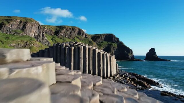 Hexagonal basalt columns at Giant's Causeway coastline on sunny day