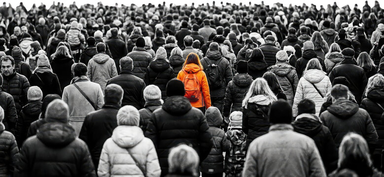 A lone woman in an orange jacket and backpack stands out in a crowd of people moving in the same direction walking movement group gathering many individuals mass humanity
