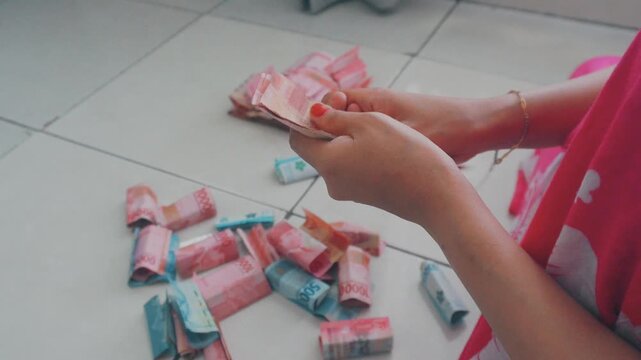 Counting money in Indonesian Rupiah, one hundred thousand and fifty thousand denominations on April 3, 2025 in Bandung, Indonesia