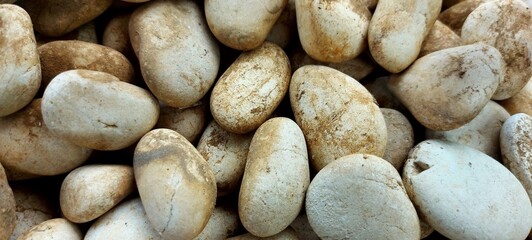 Obraz premium Close-Up of Smooth River Pebbles with Earthy Tones