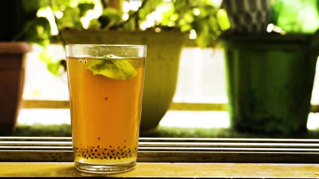 Refreshing lemon iced tea with sabja seeds drink. Healthy drink made with lemon tea and basil seeds (sabja) on table with natural light background.